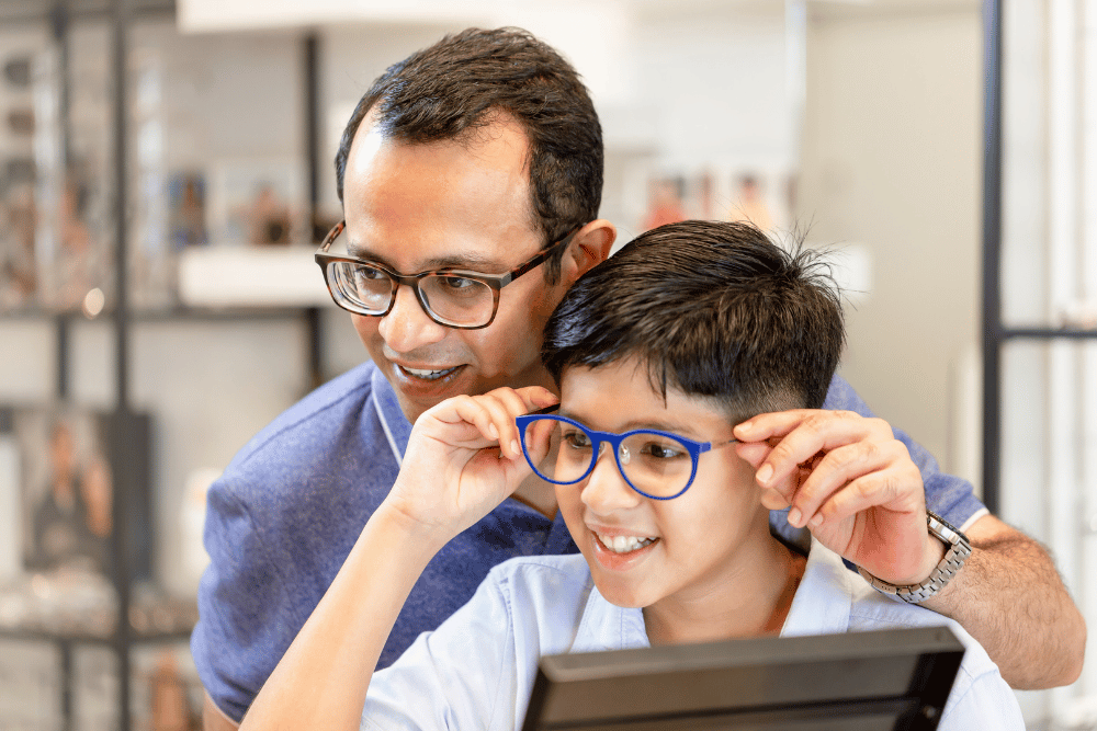 a father and son trying on eyewear in an optical