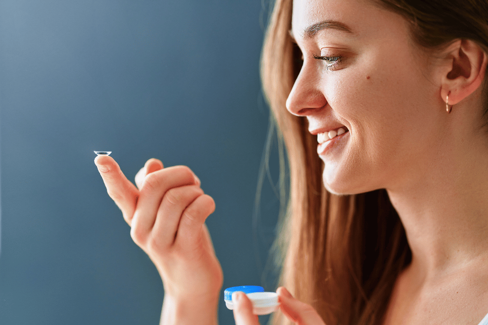 a young woman with a contact lens on her finger
