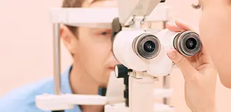 Woman checking a male patient's eyes during his eye exam